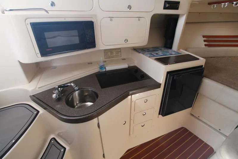 Karma Sea's Yacht Photos Pics 2001 Grady-White Express 330 boat interior with kitchenette, sink, microwave, and storage cabinets.