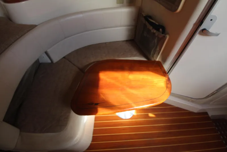 Karma Sea's Yacht Photos Pics 2001 Grady-White Express 330 cabin interior with wooden table and cushioned seating.