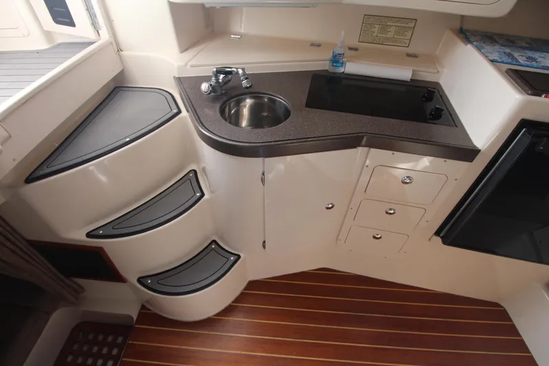 Karma Sea's Yacht Photos Pics 2001 Grady-White Express 330 boat interior with kitchenette, sink, and wooden flooring.