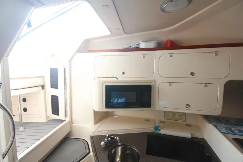 Karma Sea's Yacht Photos Pics 2001 Grady-White Express 330 boat interior with kitchenette, microwave, and storage cabinets.