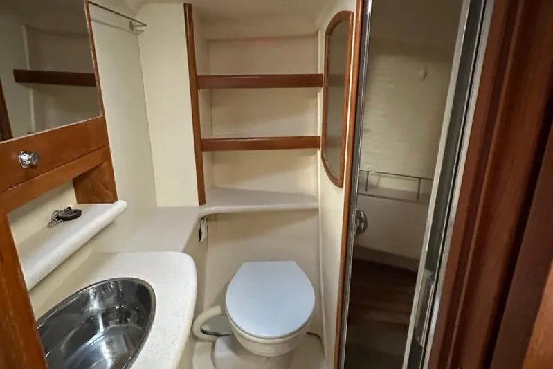 Free Range Yacht Photos Pics Compact bathroom in 2005 Hunter 44 yacht with sink, toilet, and wooden shelving.