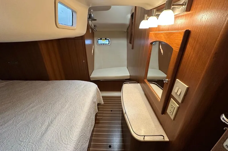 Free Range Yacht Photos Pics Interior of 2005 Hunter 44 yacht cabin with bed, mirror, and wooden finish.