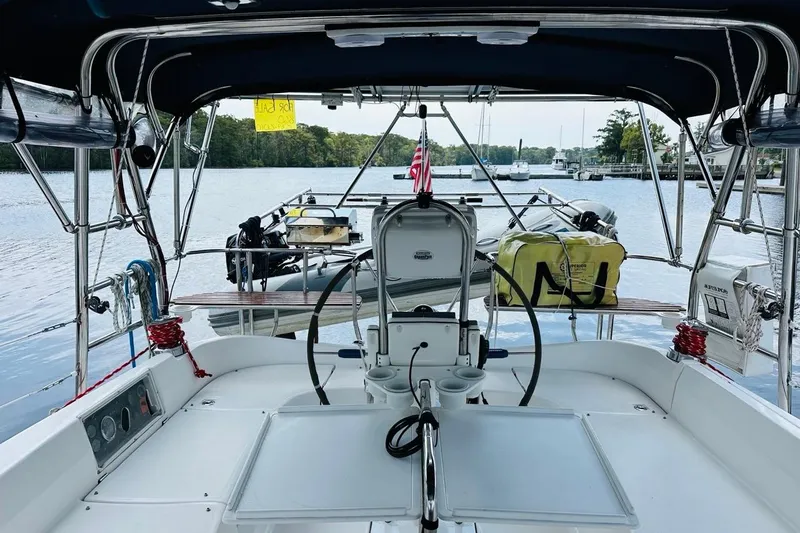 Free Range Yacht Photos Pics Cockpit view of a 2005 Hunter 44 sailboat docked by a serene waterfront.