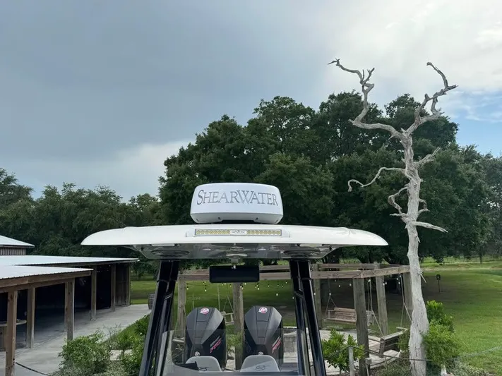  Yacht Photos Pics 2021 ShearWater 270 Carolina Flare boat with radar, parked outdoors near trees.
