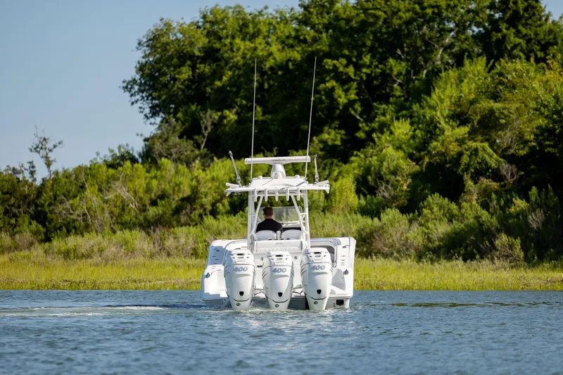  Yacht Photos Pics 2022 Yellowfin 34 boat with triple engines cruising on a serene lake.