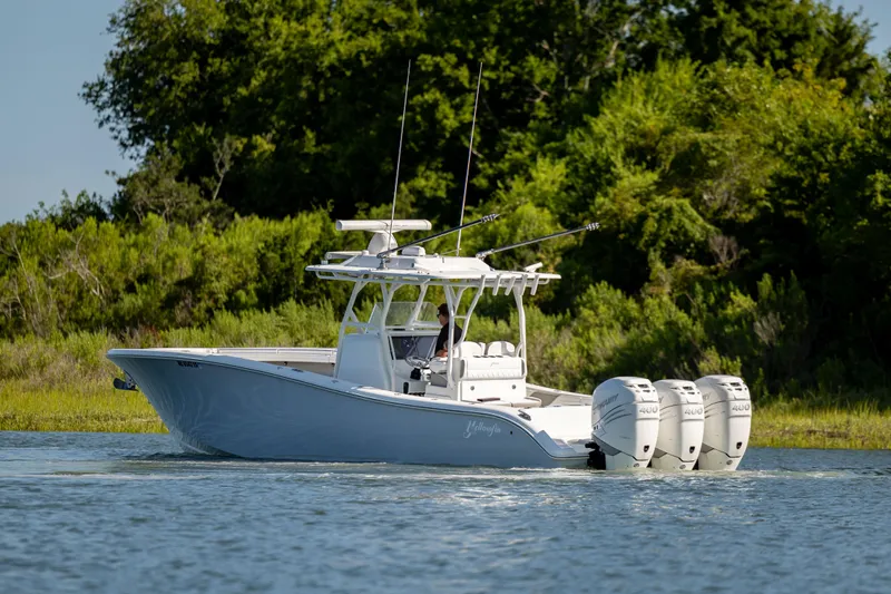  Yacht Photos Pics 2022 Yellowfin 34 boat with triple engines on a serene waterway.