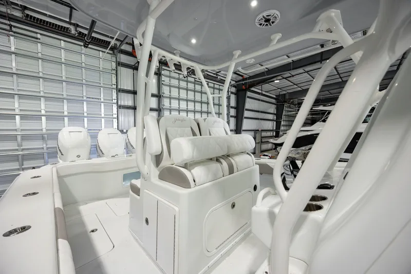  Yacht Photos Pics 2022 Yellowfin 34 boat interior with white seating and modern design in a garage.