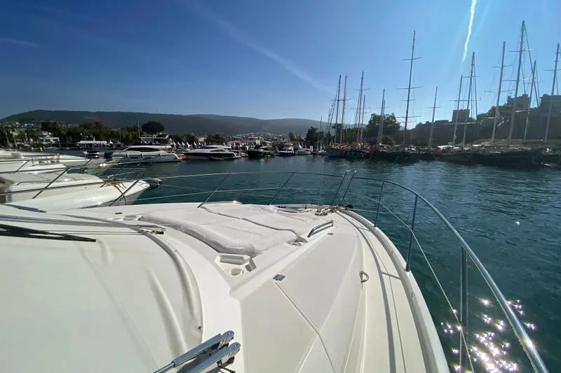 Nm01655 Yacht Photos Pics 2011 Sunseeker Manhattan 63 yacht docked in a scenic marina under clear blue skies.