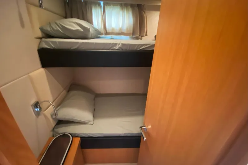 Nm01655 Yacht Photos Pics Bunk beds in 2011 Sunseeker Manhattan 63 yacht cabin, featuring cozy bedding and wooden interior.