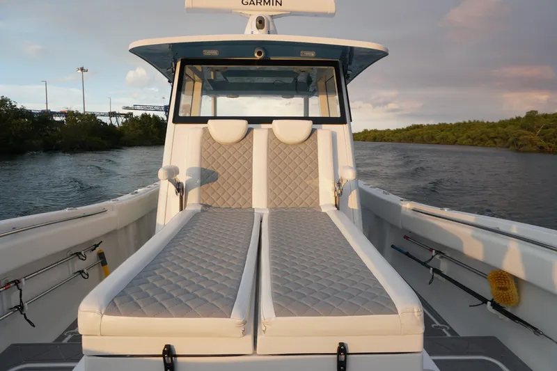  Yacht Photos Pics 2022 Insetta 35IFC boat interior with cushioned seating, on a calm waterway.