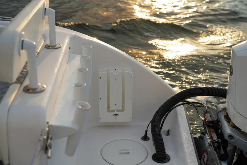  Yacht Photos Pics 2022 Insetta 35IFC boat deck with rod holders, engine, and sunlit water.