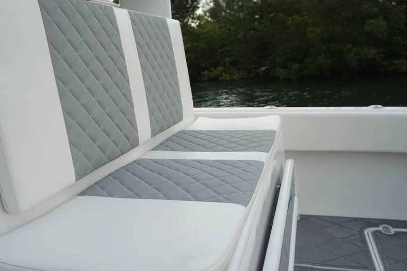  Yacht Photos Pics Quilted seating on 2022 Insetta 35IFC boat, with lush greenery in the background.