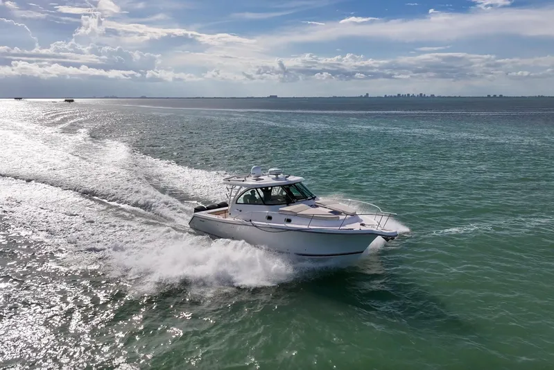  Yacht Photos Pics 2016 Pursuit OS 385 Offshore cruising on open water under a partly cloudy sky.