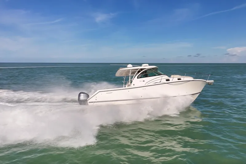  Yacht Photos Pics 2016 Pursuit OS 385 Offshore boat speeding on open water under clear blue sky.