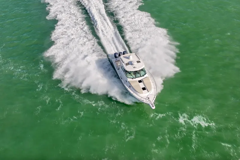  Yacht Photos Pics 2016 Pursuit OS 385 Offshore cruising on vibrant green water, aerial view.