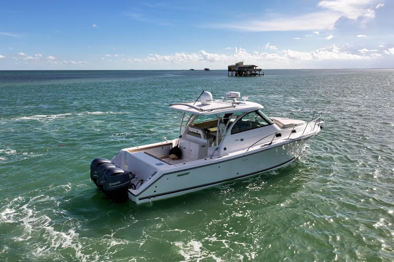  Yacht Photos Pics 2016 Pursuit OS 385 Offshore boat cruising on open water under a clear sky.