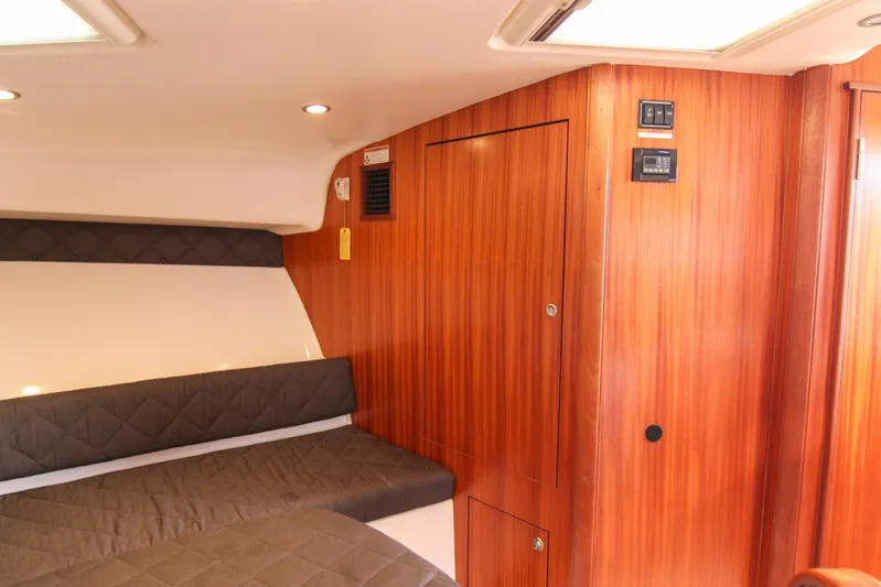  Yacht Photos Pics 2016 Pursuit OS 385 Offshore cabin interior with wood paneling and cushioned seating.