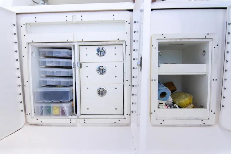  Yacht Photos Pics Storage compartments on a 2016 Pursuit OS 385 Offshore boat, featuring organized drawers and shelves.