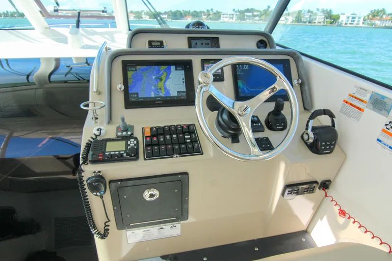  Yacht Photos Pics 2016 Pursuit OS 385 Offshore helm with navigation screens and controls, overlooking water.