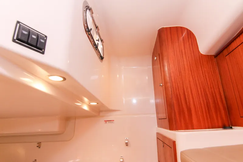  Yacht Photos Pics 2016 Pursuit OS 385 Offshore cabin interior with wood cabinetry and recessed lighting.