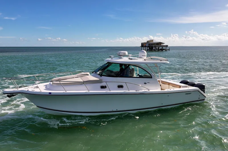  Yacht Photos Pics 2016 Pursuit OS 385 Offshore boat cruising on clear ocean waters.