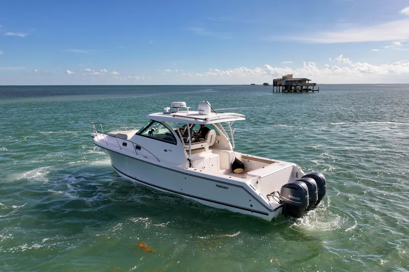 Yacht Photos Pics 2016 Pursuit OS 385 Offshore boat cruising on open water under clear skies.
