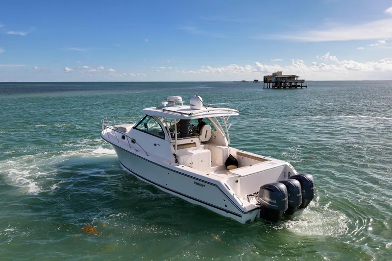  Yacht Photos Pics 2016 Pursuit OS 385 Offshore boat cruising on open water under clear blue skies.