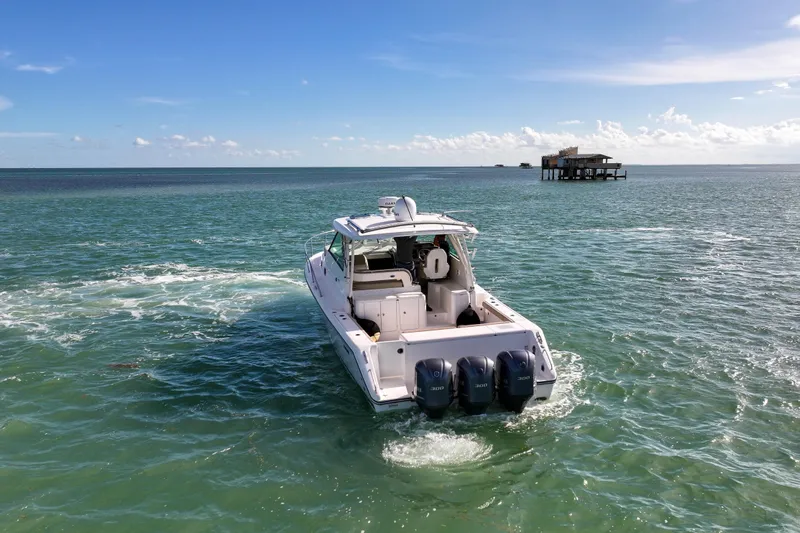  Yacht Photos Pics 2016 Pursuit OS 385 Offshore boat cruising on open water under clear skies.