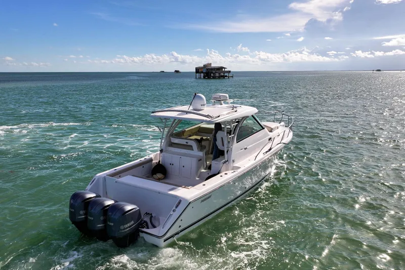  Yacht Photos Pics 2016 Pursuit OS 385 Offshore boat cruising on open water under a clear blue sky.