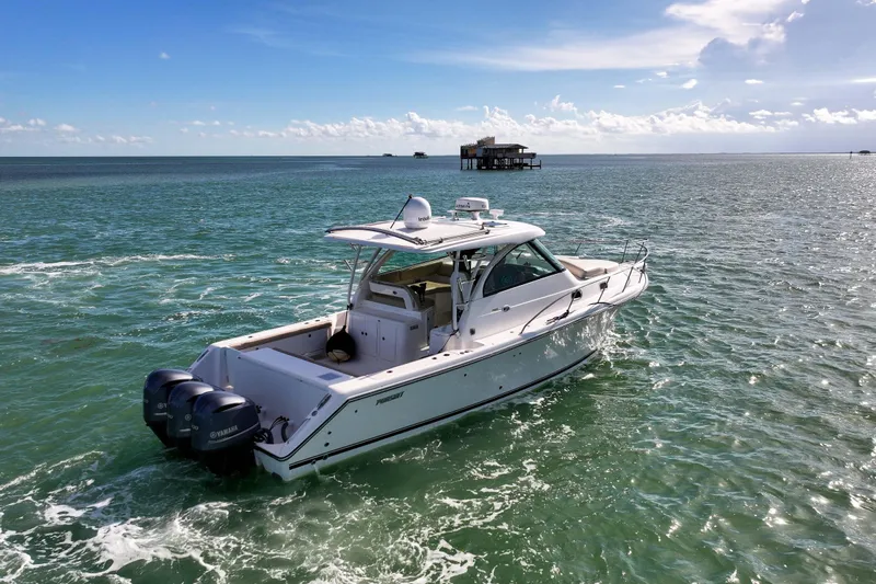  Yacht Photos Pics 2016 Pursuit OS 385 Offshore boat cruising on open water under a clear sky.