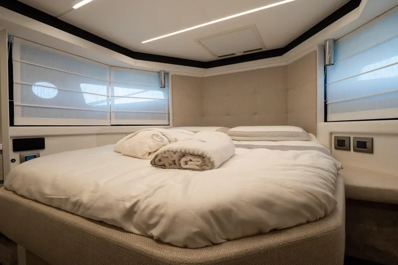 Curly Yacht Photos Pics Luxurious bedroom interior of 2021 Cranchi E52S yacht with cozy bedding and modern design.