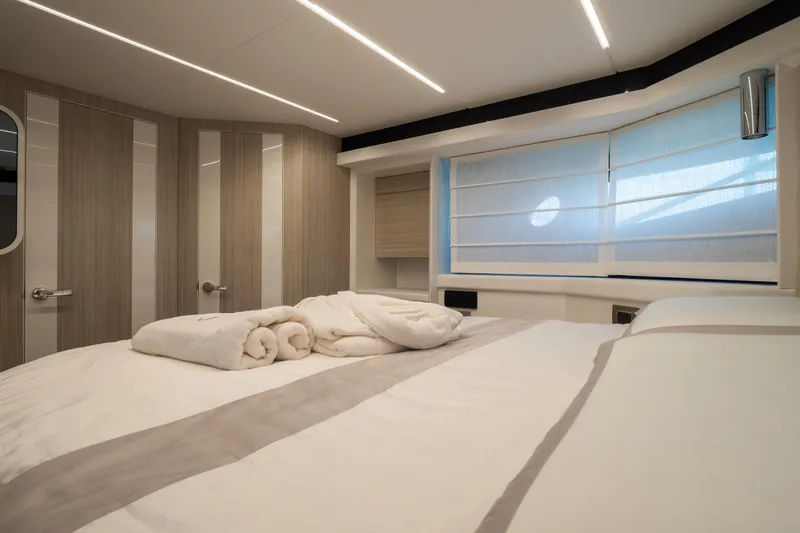 Curly Yacht Photos Pics Luxurious bedroom interior of 2021 Cranchi E52S yacht with modern design and soft lighting.