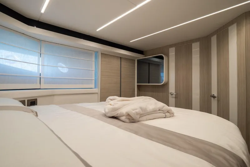 Curly Yacht Photos Pics Luxurious bedroom interior of 2021 Cranchi E52S yacht with modern design and soft lighting.