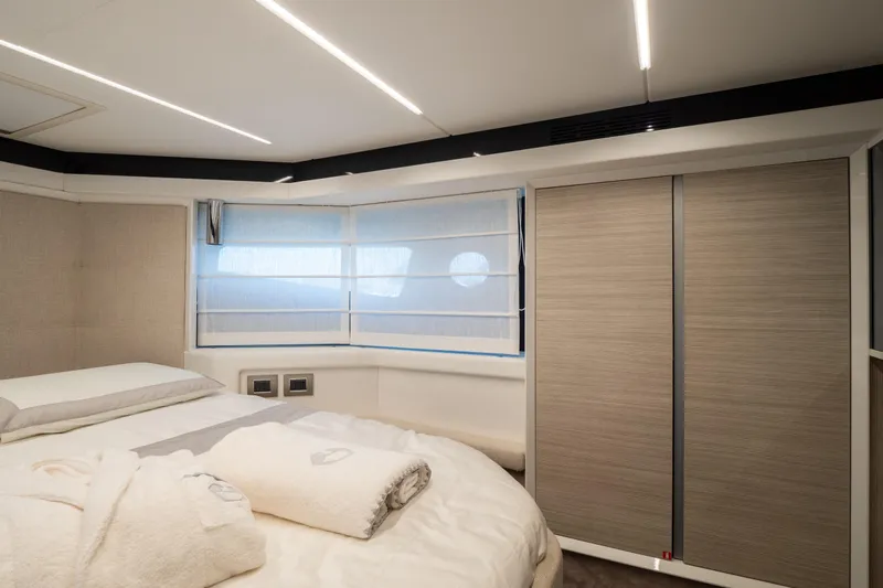 Curly Yacht Photos Pics Luxurious bedroom interior of 2021 Cranchi E52S yacht with modern design and soft lighting.