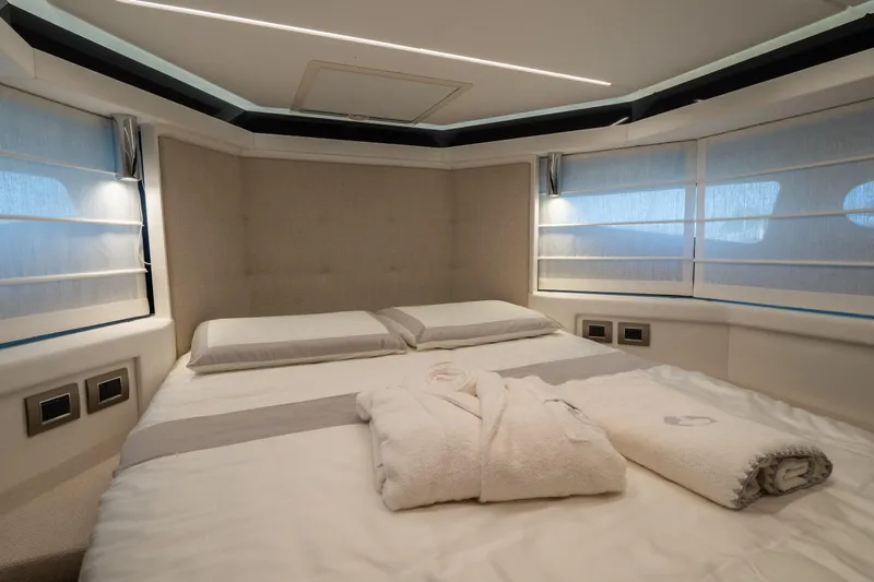 Curly Yacht Photos Pics Luxurious bedroom interior of 2021 Cranchi E52S yacht with elegant bedding and soft lighting.