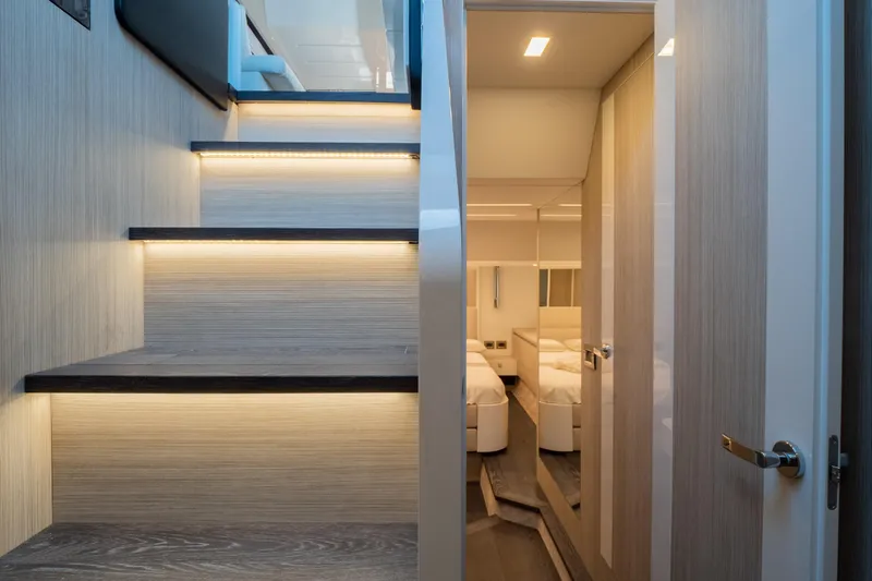Curly Yacht Photos Pics Interior of 2021 Cranchi E52S yacht, featuring illuminated stairs and modern bedroom.