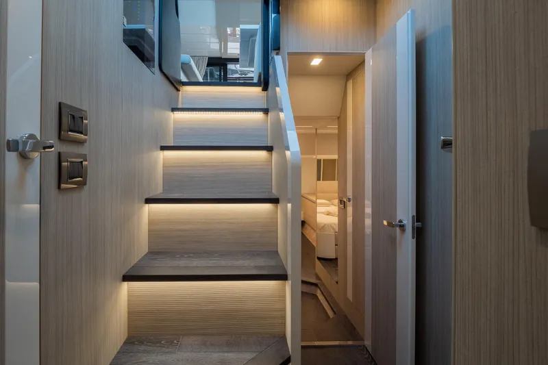 Curly Yacht Photos Pics Modern interior of 2021 Cranchi E52S yacht with illuminated stairs and sleek design.