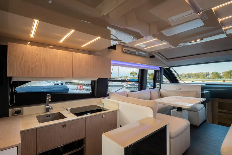 Curly Yacht Photos Pics Luxurious interior of 2021 Cranchi E52S yacht with modern kitchen and seating area.