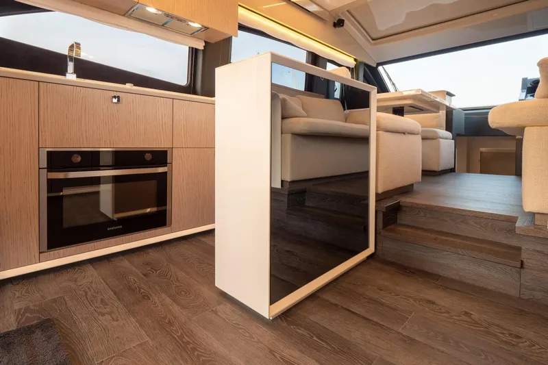 Curly Yacht Photos Pics Luxurious interior of 2021 Cranchi E52S yacht with modern kitchen and seating area.