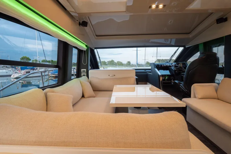 Curly Yacht Photos Pics Luxurious interior of 2021 Cranchi E52S yacht with beige seating and modern helm.