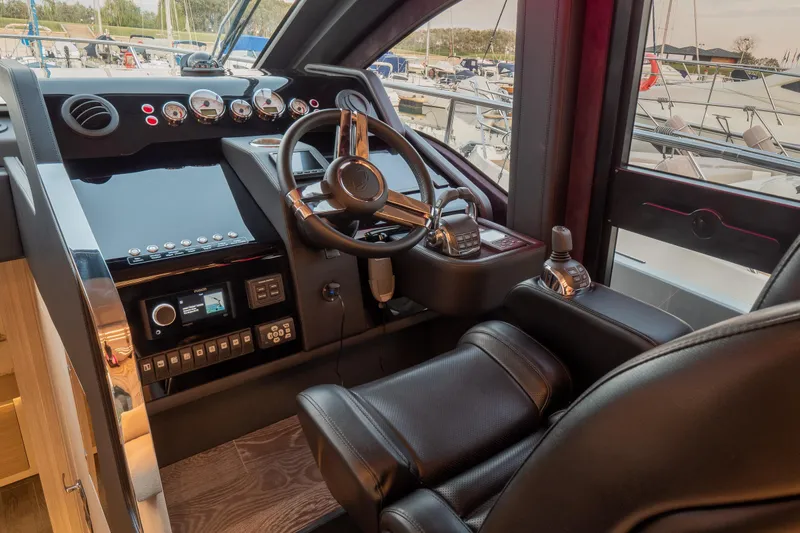 Curly Yacht Photos Pics Luxurious helm of 2021 Cranchi E52S yacht with modern controls and leather seating.