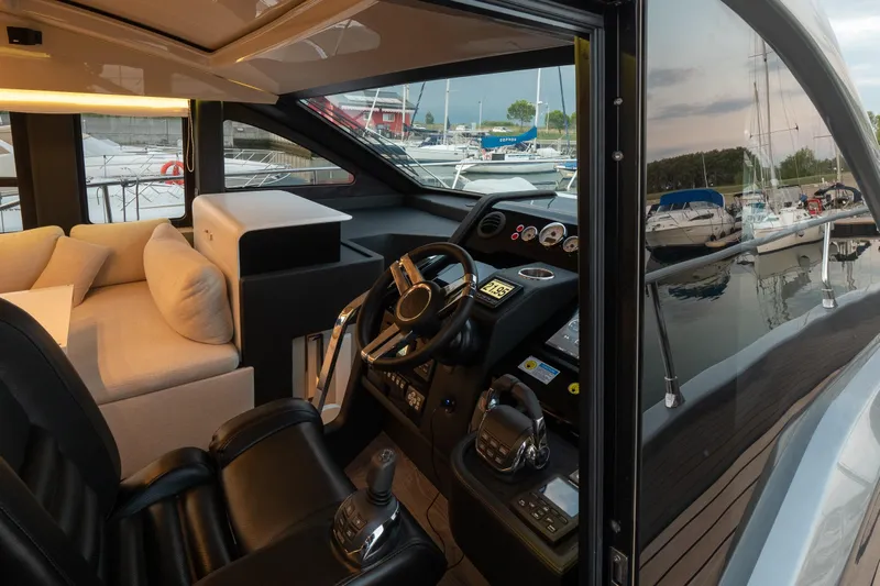 Curly Yacht Photos Pics Interior view of 2021 Cranchi E52S yacht cockpit with luxurious seating and control panel.