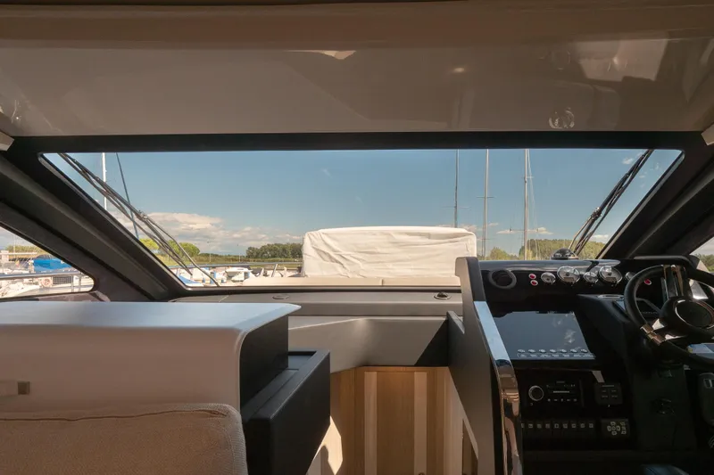 Curly Yacht Photos Pics Interior view of 2021 Cranchi E52S yacht cockpit with modern controls and marina backdrop.