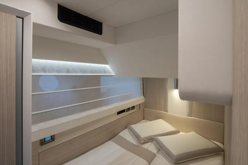 Curly Yacht Photos Pics Luxurious cabin interior of 2021 Cranchi E52S yacht with modern bedding and ambient lighting.