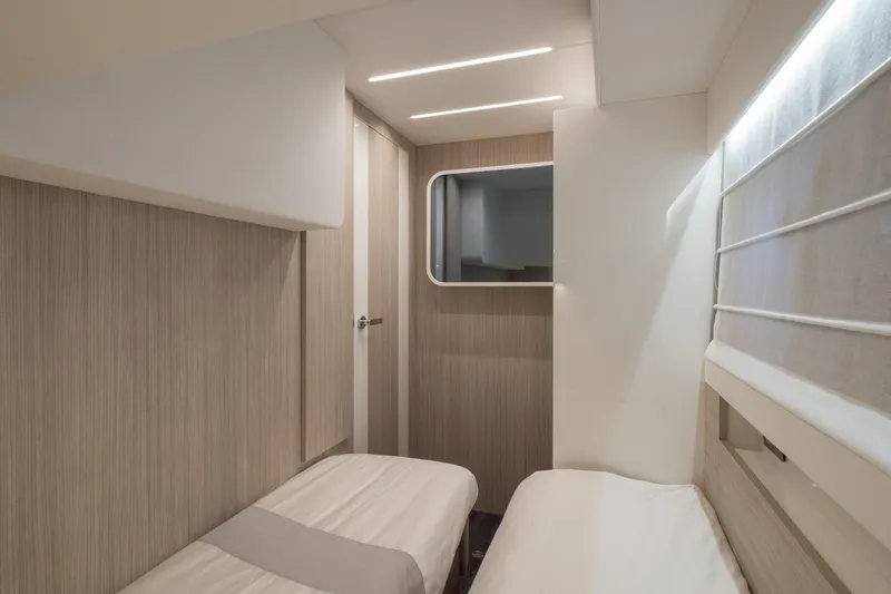 Curly Yacht Photos Pics Modern interior cabin of 2021 Cranchi E52S yacht with twin beds and sleek design.