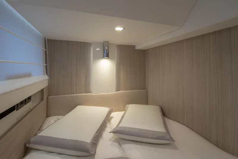 Curly Yacht Photos Pics Luxurious cabin interior of 2021 Cranchi E52S yacht with modern bedding and soft lighting.