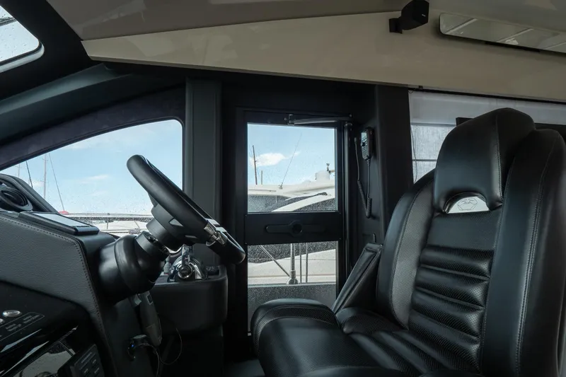 Curly Yacht Photos Pics Interior of 2021 Cranchi E52S yacht showing steering wheel and luxurious seating.