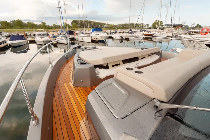 Curly Yacht Photos Pics 2021 Cranchi E52S yacht with sleek deck and luxurious seating in a marina.