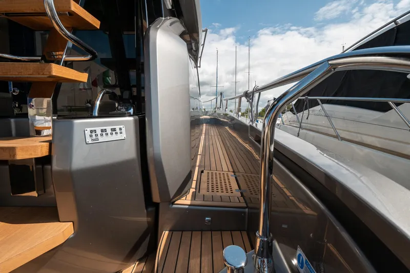 Curly Yacht Photos Pics 2021 Cranchi E52S yacht deck with wooden flooring and sleek metal railings.