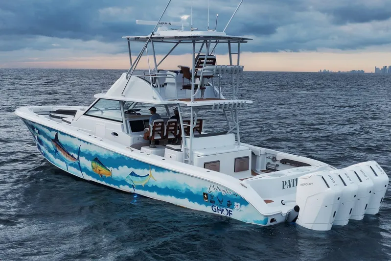  Yacht Photos Pics 2022 Yellowfin 54 Offshore boat with vibrant marine artwork, cruising on open water.